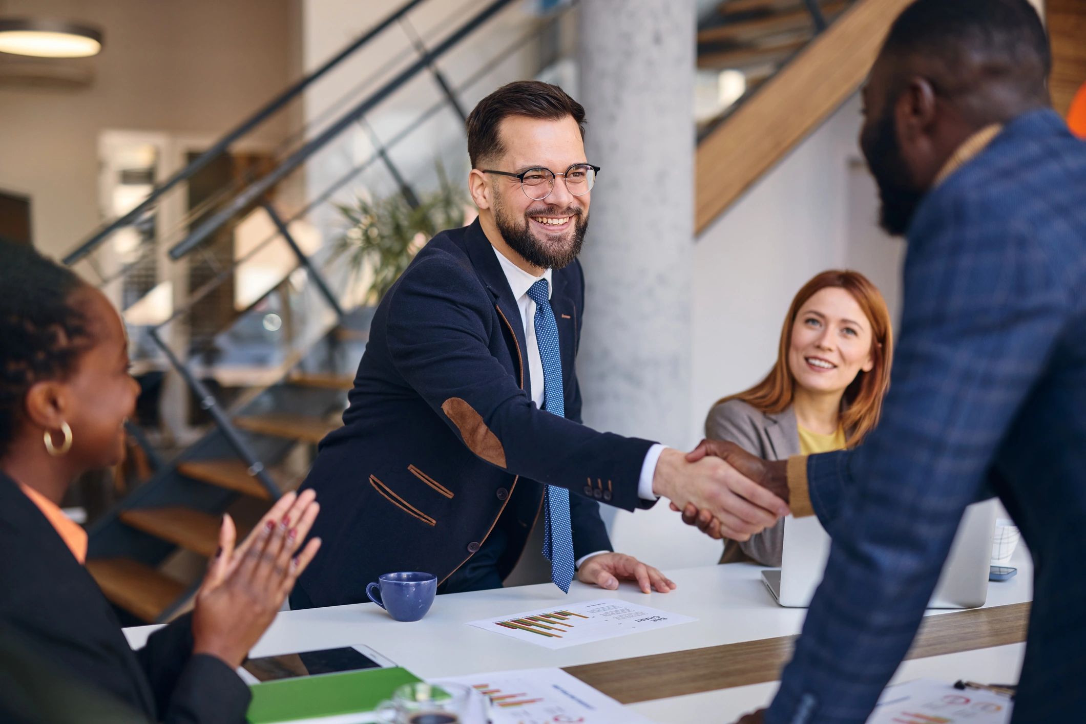 Business partners shaking hands after successful meeting in modern office